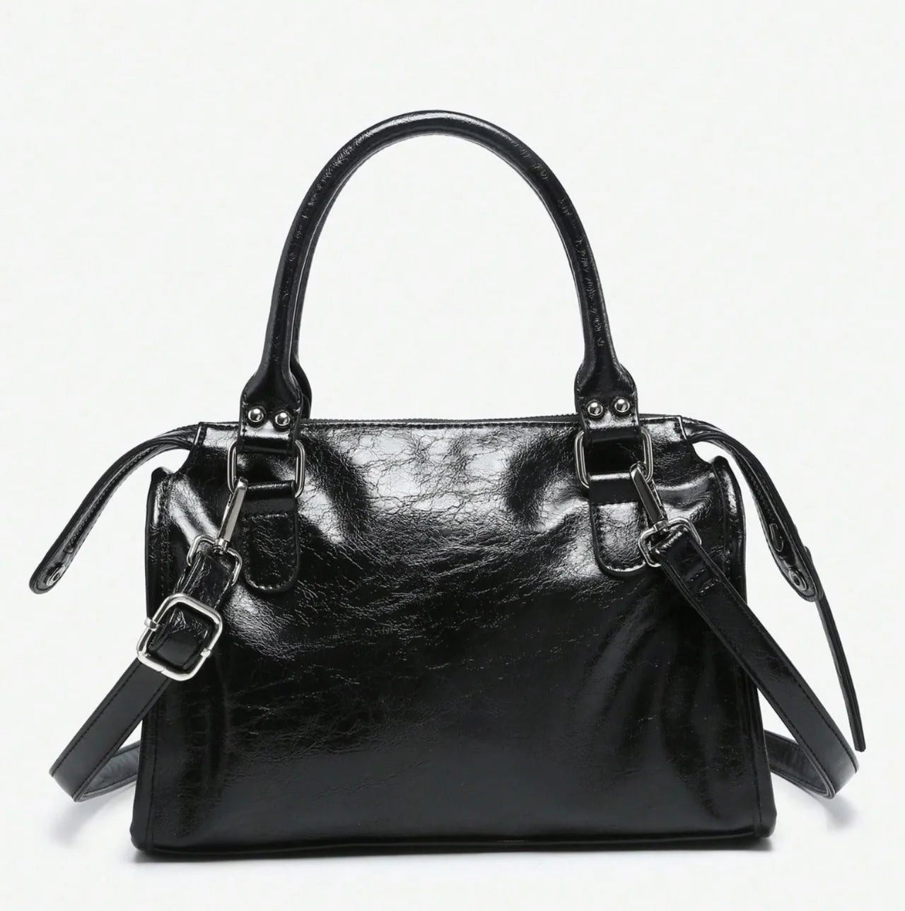 Sac à main CARLA en cuir noir effet brillant, avec détails métalliques, finitions soignées, anses solides, bandoulière réglable et grand compartiment zippé, parfait pour le travail et les sorties, vue dos.