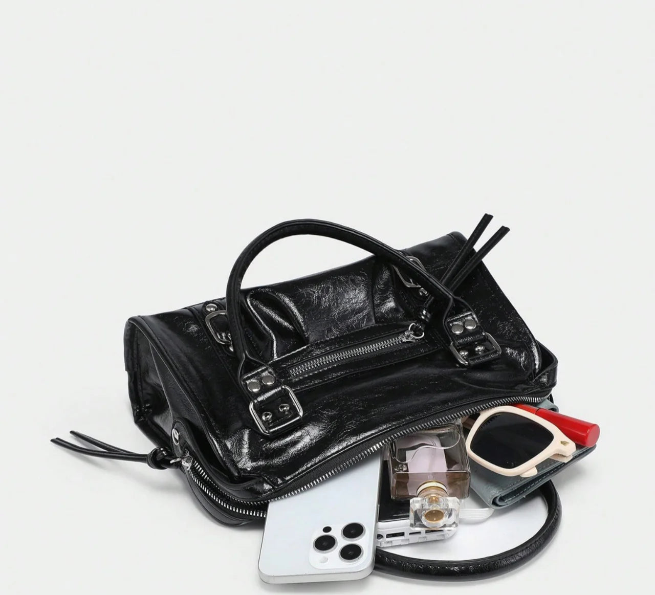 Sac à main CARLA en cuir noir effet brillant, avec détails métalliques, finitions soignées, anses solides, bandoulière réglable et grand compartiment zippé, parfait pour le travail et les sorties, vue intérieur du sac.