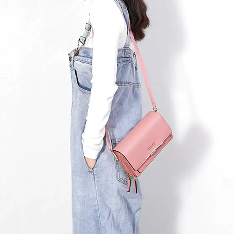 Sac à main CASSIE en cuir synthétique rose, bandoulière ajustable, avec rabat, compartiments et poches pour organiser vos essentiels avec style et praticité, porté en bandoulière.