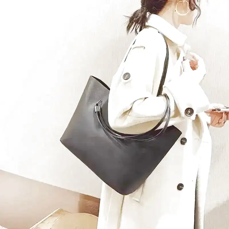 EMELINA - Grand Sac à Main Cabas en Cuir Souple Noir pour Femme, porté épaule.