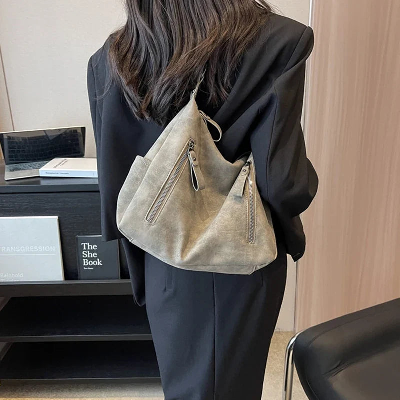 Découvrez Hilona, grand sac à main en suède spacieux et raffiné, idéal pour transporter vos essentiels avec style au quotidien ou lors de vos sorties.