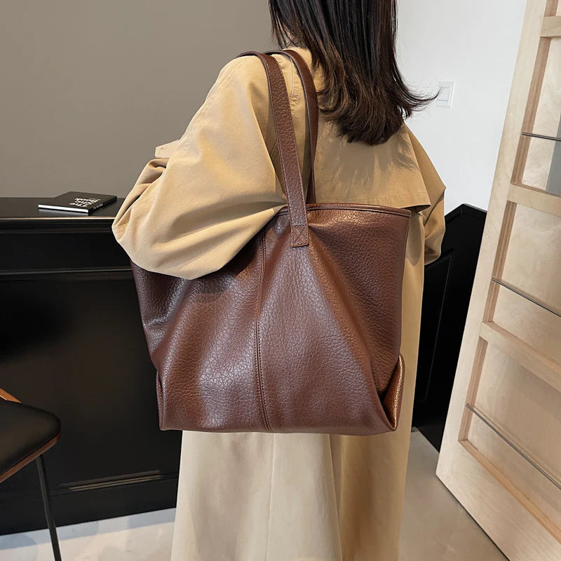 Sac à main KIM en cuir synthétique café, moderne et pratique, grand sac tote bag avec intérieur spacieux et finitions soignées, parfait pour le quotidien et le travail, porté épaule.