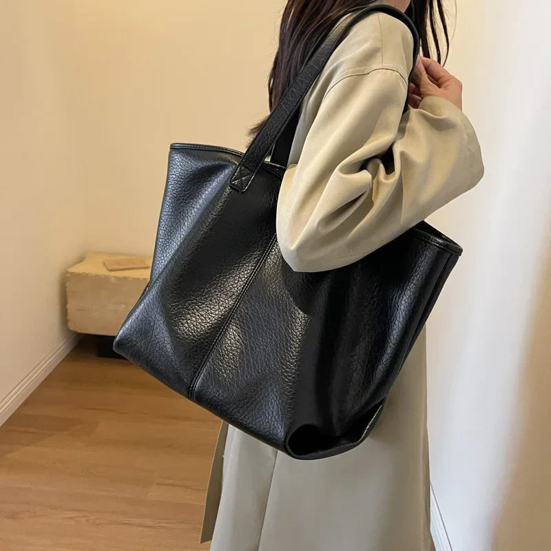 Sac à main KIM en cuir synthétique noir, moderne et pratique, grand sac tote bag avec intérieur spacieux et finitions soignées, parfait pour le quotidien et le travail, porté épaule.