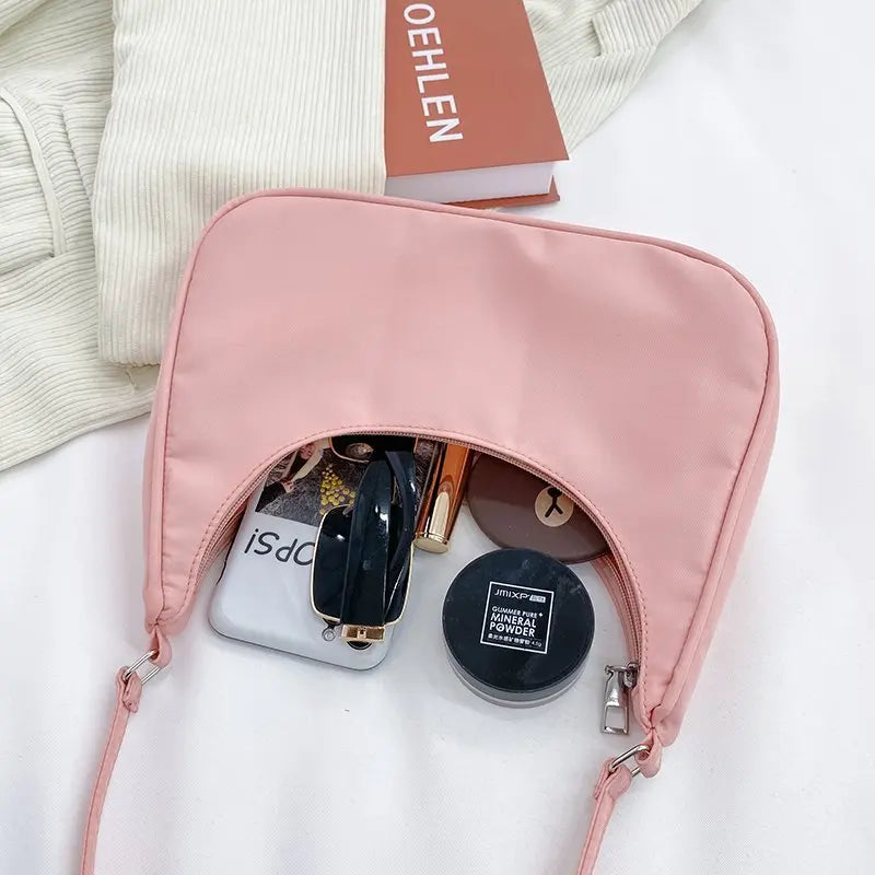 Petit sac à main MELIA en cuir vegan souple rose format compact avec design chic et minimaliste, idéal pour une sortie élégante.