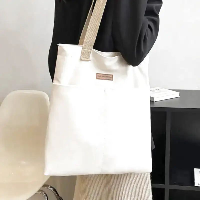 Grand sac cabas REGINA en cuir vegan blanc élégant et résistant, parfait pour transporter ordinateur, dossiers et essentiels quotidiens avec style et confort.