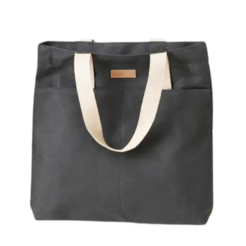 Grand sac cabas REGINA en cuir vegan noir élégant et résistant, parfait pour transporter ordinateur, dossiers et essentiels quotidiens avec style et confort.