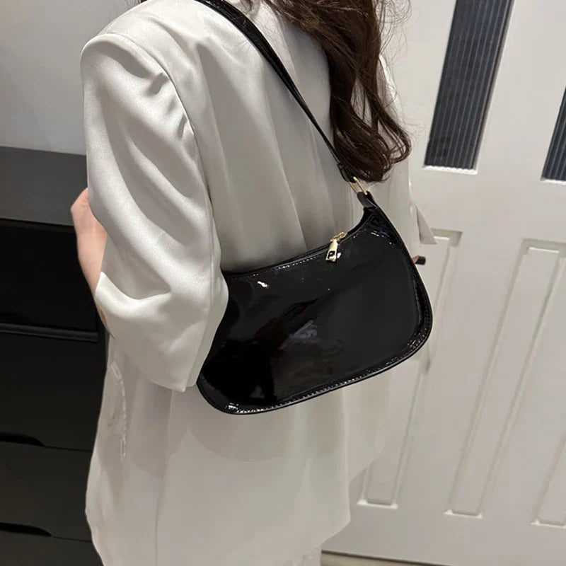 Sac à main SYA petit format vernis noir, design raffiné et lumineux, idéal pour transporter vos essentiels avec style lors de vos sorties